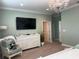 Spacious main bedroom with large TV, dresser, and stylish decor with soft green walls at 3397 Sagebrush St, Harmony, FL 34773