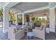 Covered outdoor patio with stylish wicker furniture and stone fireplace at 3397 Sagebrush St, Harmony, FL 34773