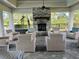 Outdoor patio with a stone fireplace and comfortable lounge seating beneath a pergola at 3397 Sagebrush St, Harmony, FL 34773