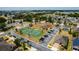 Aerial view of a community featuring tennis court, playground, parking, and well-maintained homes surrounded by lush trees at 344 Cadiz Loop, Davenport, FL 33837