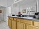 Bathroom with double sinks, wood cabinets, and walk-in shower at 344 Cadiz Loop, Davenport, FL 33837