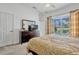 Bedroom featuring neutral decor, a dark wood dresser, and sliding glass doors showcasing the screened pool at 344 Cadiz Loop, Davenport, FL 33837