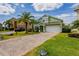 Two-story home featuring a brick driveway, lush lawn, and tasteful landscaping at 344 Cadiz Loop, Davenport, FL 33837