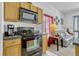 Well-equipped kitchen with a black oven, wood cabinetry, and laminate countertops at 344 Cadiz Loop, Davenport, FL 33837