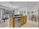 Open-concept kitchen with stainless steel dishwasher, wood cabinets, and adjacent living area at 344 Cadiz Loop, Davenport, FL 33837