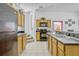 Bright kitchen features tile floors, black appliances, and oak cabinetry at 344 Cadiz Loop, Davenport, FL 33837