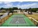 Community tennis and basketball court with green surface, surrounded by black fence and houses, for active recreation at 344 Cadiz Loop, Davenport, FL 33837