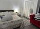 Cozy bedroom with floral bedding, white walls, and a red chair at 3772 Huntwicke Blvd, Davenport, FL 33837