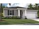 Charming one-story home with a gray exterior, dark shutters and an attached two-car garage at 398 Eventide Ave, Mascotte, FL 34753