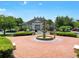 Community clubhouse with a tiered fountain, manicured landscaping, and ample parking at 4560 Spigold Court, Kissimmee, FL 34746