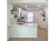 Bright kitchen with white cabinetry, modern appliances, quartz countertops, and floating shelves at 5284 Indian Laurel Ct, Orlando, FL 32808