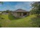View of the backyard of a stucco house with a grassy lawn and covered porch at 543 Nardello Dr, Deltona, FL 32725