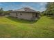 The home has a spacious backyard featuring lush green grass, solar panels and a covered patio at 543 Nardello Dr, Deltona, FL 32725