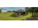 Panoramic backyard view with grass, house with solar panels, and small patio at 543 Nardello Dr, Deltona, FL 32725