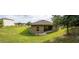 Panoramic backyard view with grass, house with solar panels, and small patio at 543 Nardello Dr, Deltona, FL 32725