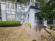 Two-story condo exterior showing a patio with metal fence and a small shrub surrounded by light green grass and foliage at 5525 Pga Blvd # 4611, Orlando, FL 32839