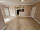 Open living area with tile flooring, neutral paint, and a partial view of the kitchen at 5525 Pga Blvd # 4611, Orlando, FL 32839