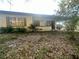 Single story home with neutral tone and front lawn covered with leaves at 628 Cardinal St, Ocoee, FL 34761