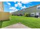 View of backyards of townhomes featuring green lawns, small patios, and mature trees at 725 Cresting Oak Cir # 117, Orlando, FL 32824