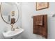 Bathroom featuring a stylish rope-framed mirror and pedestal sink at 725 Cresting Oak Cir # 117, Orlando, FL 32824