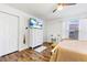 Bedroom featuring wood look flooring, a tv, and a window with blinds at 725 Cresting Oak Cir # 117, Orlando, FL 32824