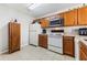 A kitchen featuring wooden cabinets and white appliances including refrigerator, oven, dishwasher, and microwave at 725 Cresting Oak Cir # 117, Orlando, FL 32824