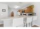 A kitchen featuring a breakfast bar with white bar stools and wooden cabinets with updated appliances at 725 Cresting Oak Cir # 117, Orlando, FL 32824