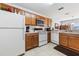 A kitchen featuring wooden cabinets and white appliances including refrigerator, oven, dishwasher at 725 Cresting Oak Cir # 117, Orlando, FL 32824