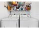 Laundry room showing a top shelf lined with laundry products above the washer and dryer at 725 Cresting Oak Cir # 117, Orlando, FL 32824