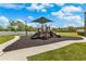 A playground featuring a shade structure over the play equipment and dark mulch as a ground covering at 725 Cresting Oak Cir # 117, Orlando, FL 32824
