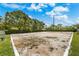 A sand volleyball court with a white border is surrounded by green lawns and landscaping at 725 Cresting Oak Cir # 117, Orlando, FL 32824