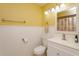 Bright bathroom featuring white vanity, white wainscoting and yellow painted walls at 7254 Della Dr, Orlando, FL 32819