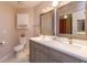 Bright bathroom featuring a double vanity, framed mirrors, and a separate toilet area for added privacy at 7254 Della Dr, Orlando, FL 32819