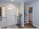 Bright foyer featuring a white door, decorative rug, modern flooring, and staircase leading to the upper level at 7254 Della Dr, Orlando, FL 32819