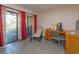 Bright office space with sliding glass doors, red curtains, tile floors, and a work area with desk and chair at 7254 Della Dr, Orlando, FL 32819