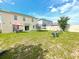 Large backyard with green grass, swing set, trampoline and an outdoor dining set at 9040 Alba Ln, Kissimmee, FL 34747