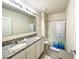 Bathroom featuring a double vanity with granite countertop, toilet, and shower/tub combo at 9040 Alba Ln, Kissimmee, FL 34747