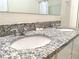 Bathroom with a granite countertop vanity featuring dual sinks and chrome fixtures at 9040 Alba Ln, Kissimmee, FL 34747