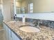 Bright bathroom featuring a double vanity with granite countertop and a large mirror at 9040 Alba Ln, Kissimmee, FL 34747