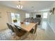 Open-concept dining area with a long table, modern light fixture, and backyard view at 9040 Alba Ln, Kissimmee, FL 34747