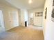 Carpeted hallway with neutral walls, several doorways and laundry room access at 9040 Alba Ln, Kissimmee, FL 34747