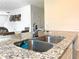 Kitchen island with granite countertop, stainless steel sink, and faucet fixture at 9040 Alba Ln, Kissimmee, FL 34747