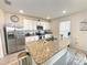 Bright kitchen features stainless steel appliances, granite counters, and a large island with a sink at 9040 Alba Ln, Kissimmee, FL 34747