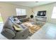 Living room with a gray sectional sofa, tile flooring, and a modern area rug at 9040 Alba Ln, Kissimmee, FL 34747