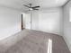 Spacious bedroom with plush carpet, a ceiling fan, and a wide closet for ample storage at 9345 Buttonwood St, Orlando, FL 32825