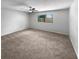 Clean and bright bedroom features neutral carpet, a ceiling fan, and a window offering natural light at 9345 Buttonwood St, Orlando, FL 32825