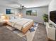 A cozy bedroom featuring a ceiling fan, neutral color scheme, and a large window for natural light at 9345 Buttonwood St, Orlando, FL 32825