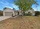 Charming single-story home featuring a stone accent facade, attached garage, and a well-maintained front yard at 9345 Buttonwood St, Orlando, FL 32825