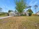 Charming single-story home featuring a stone accent facade, attached garage, and a well-maintained front yard at 9345 Buttonwood St, Orlando, FL 32825