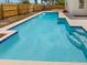 Backyard pool showcasing crystal-clear blue water, integrated steps, and a smooth concrete surround, perfect for summer enjoyment at 9345 Buttonwood St, Orlando, FL 32825